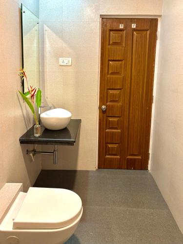 a bathroom with a toilet and a sink and a door at Casa de Laura in Calangute