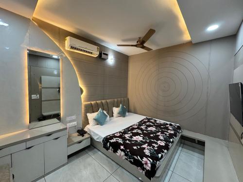 a room with a bed with a mirror and a tv at Hotel Guruvayur Dham in Mathura