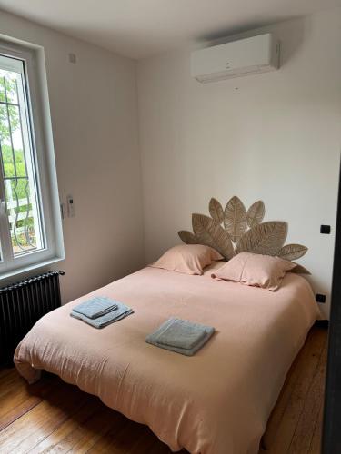 une chambre avec un grand lit avec deux serviettes dessus dans l'établissement Le Clos Monial sleeps 8, à La Celle-sous-Gouzon