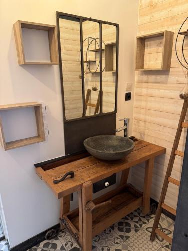 La salle de bains est pourvue d'un lavabo et d'un miroir sur une table. dans l'établissement Le Clos Monial sleeps 8, à La Celle-sous-Gouzon