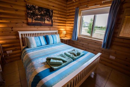 a bedroom with a bed in a log cabin at Partridge Lodge in Selby
