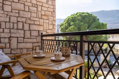 a wooden table on a balcony with two tea cups at Giogarakis Suites in Eleonas