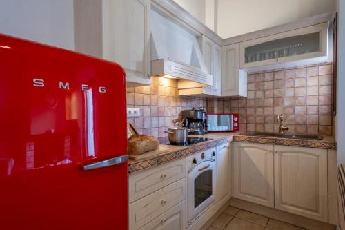a kitchen with white cabinets and a red refrigerator at Giogarakis Suites in Eleonas