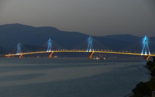 a bridge over a body of water at night at Hotel Antirriο in Antirrio