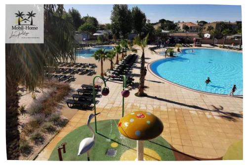 - une piscine avec des chaises et des personnes dans un complexe dans l'établissement Mobil-home aux Sables du Midi chez Catherine et Bernard., à Valras-Plage