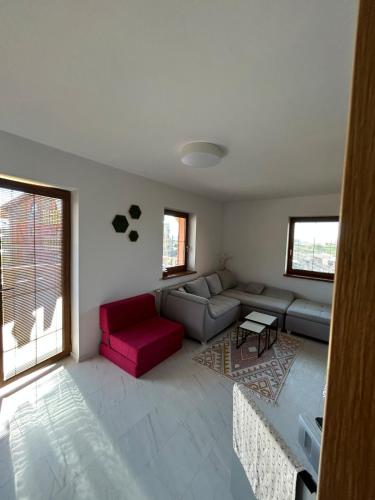 - un salon avec un canapé et un fauteuil rouge dans l'établissement Tatragolf Mountain Resort Apartment, à Veľká Lomnica