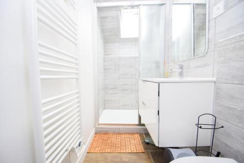 une salle de bain blanche avec un lavabo et des toilettes dans l'établissement Maison 4 pers cosy avec terrasse et Wifi, à Langrolay