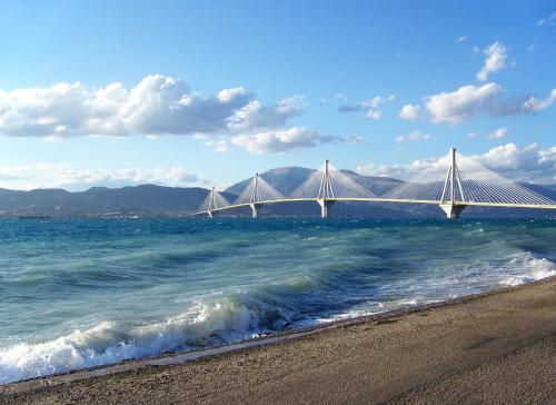 a bridge over a body of water with a beach at Hotel Antirriο in Antirrio