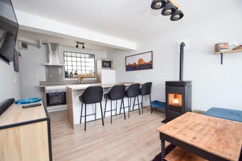 une cuisine et un salon avec une table et des chaises dans l'établissement Maison 4 pers cosy avec terrasse et Wifi, à Langrolay