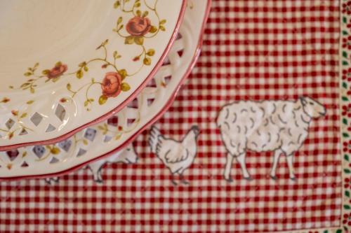 a plate with a cow and a cat on a red checked table cloth at Giogarakis Suites in Eleonas