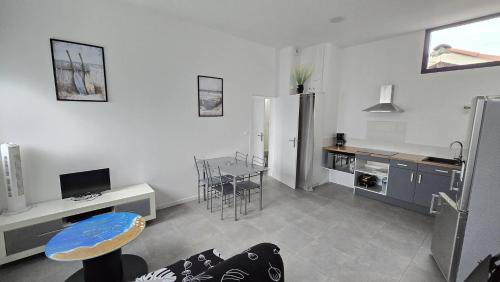 - une cuisine avec un réfrigérateur et une table dans la chambre dans l'établissement Terrasses Océan B 24, à Mimizan-Plage