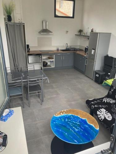 un salon avec une cuisine avec une planche de surf sur une table dans l'établissement Terrasses Océan B 24, à Mimizan-Plage