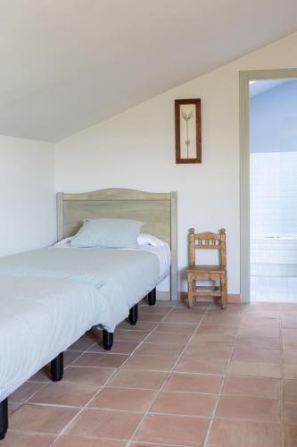 a bedroom with two beds and a chair at Hotel Boutique Moli El Canyisset in Gandía