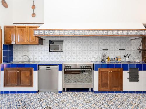 a kitchen with blue and white tiles on the wall at Villa Carolina Sorrento Private Heated Pool and Sea View in Sorrento