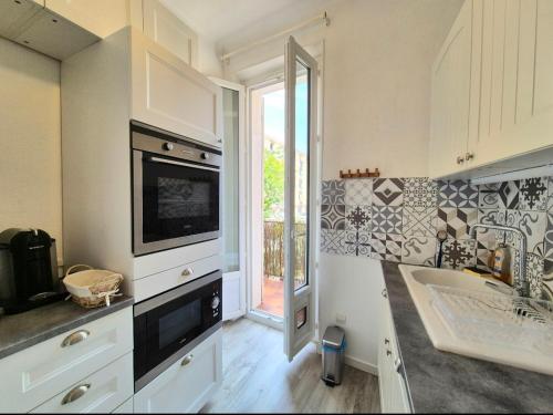 une cuisine avec un évier et un micro-ondes dans l'établissement Carolina, T3 centre historique de Bandol, à Bandol