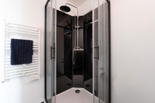 een douche met een glazen deur in een badkamer bij Santorin Îlot de Merville - Centre in Lorient