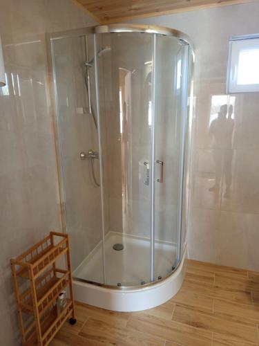 a shower with a glass door in a bathroom at La Cabane Family in Rewal