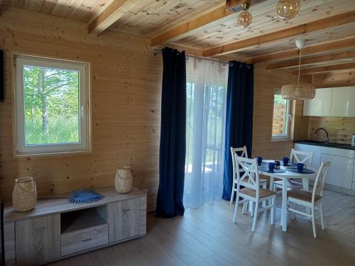 a kitchen and dining room with a table and chairs at La Cabane Family in Rewal