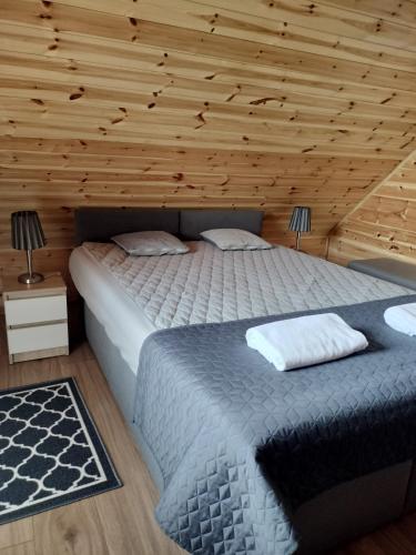 a bedroom with a bed and a wooden wall at La Cabane Family in Rewal