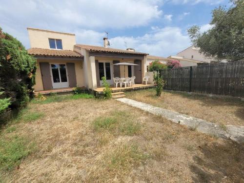 une petite maison avec une clôture dans une cour dans l'établissement Quartier des Goélands Villa t5 pour 8 personnes N25, à La Grande Motte