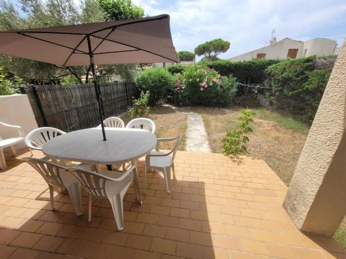 - une table, des chaises et un parasol sur la terrasse dans l'établissement Quartier des Goélands Villa t5 pour 8 personnes N25, à La Grande Motte