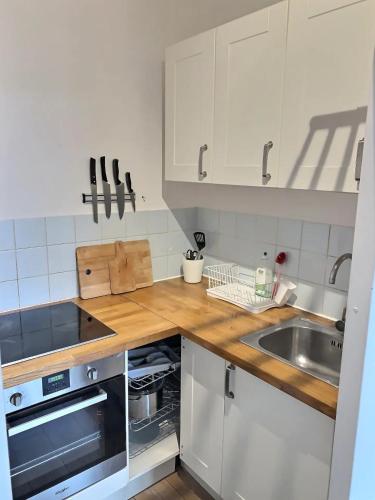 une cuisine avec des armoires blanches et un évier dans l'établissement Hossegor plage, un rêve pour les surfeurs !, à Hossegor