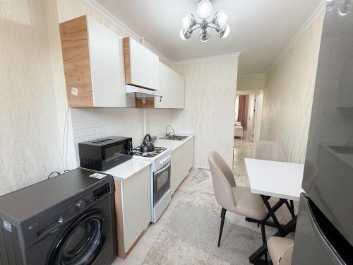 een keuken met een wasmachine en een eetkamer bij Восточный уют 2 in Samarkand