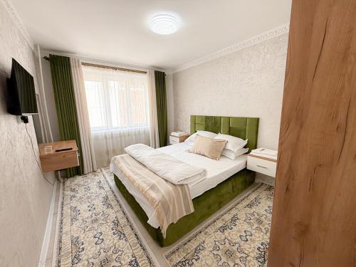 een slaapkamer met een bed en een raam bij Восточный уют 2 in Samarkand