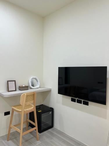 a chair in a room with a television on a wall at 小島之後After Island in Liu-ch'iu Yü