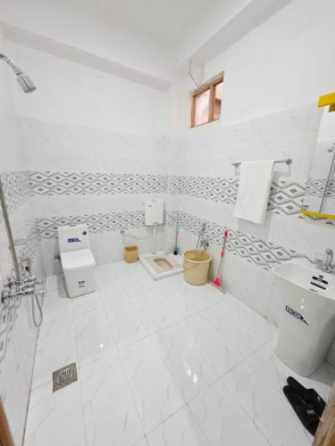 a white bathroom with two toilets and a sink at Beach Resort in Kalām