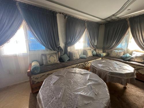 a bedroom with two beds and windows at Villa MANSOURA in Driouch