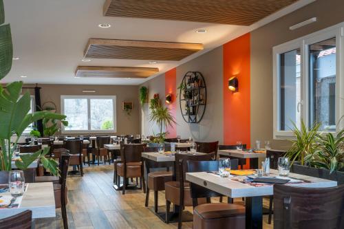 un restaurant avec des tables, des chaises et des fenêtres dans l'établissement La route verte, à Docelles