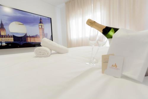 a table with a bottle of wine and two wine glasses at Hacienda Guadalquivir in Córdoba
