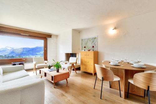 un salon avec un canapé, une table et des chaises dans l'établissement Appartement Mont d Arbois Megeve sur les pistes de ski, à Megève