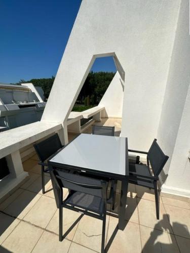 une table blanche et des chaises sur un balcon dans l'établissement Secteur Golf Appartement t2 pour 4 personnes N52, à La Grande Motte