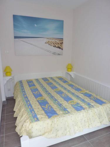 un lit avec une couette dessus dans une chambre dans l'établissement Cœur de ville Appartement t2 pour 4 personnes N15, à La Grande Motte