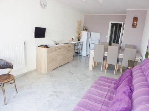 un salon avec un canapé violet et une salle à manger dans l'établissement Première ligne Mer Appartement t3 duplex pour 6 personnes N5, à La Grande Motte
