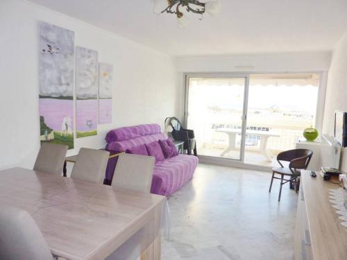 un salon avec un canapé violet et une table dans l'établissement Première ligne Mer Appartement t3 duplex pour 6 personnes N5, à La Grande Motte