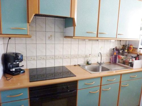 une cuisine avec des armoires bleues et un évier dans l'établissement Première ligne Mer Appartement t3 duplex pour 6 personnes N5, à La Grande Motte