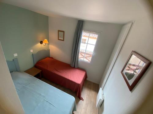 une petite chambre avec deux lits et une fenêtre dans l'établissement Maison 6 personnes de 40m2, 2 chambres, 1 salon, à Monflanquin