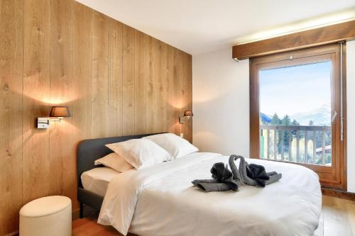 une chambre avec un lit avec deux serviettes dessus dans l'établissement Appartement Mont d Arbois Megeve sur les pistes de ski, à Megève