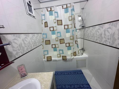 a bathroom with a shower curtain and a sink at Villa MANSOURA in Driouch