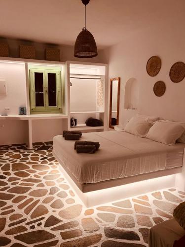 a bedroom with two beds in a room with a rug at ZIMARAKI Houses in Chora Folegandros