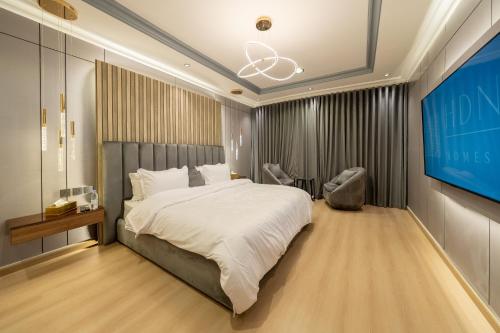 een slaapkamer met een groot bed en een flatscreen-tv bij Luxuries Apt,Self-Entry,65 4K TV Smart A4 in Riyad