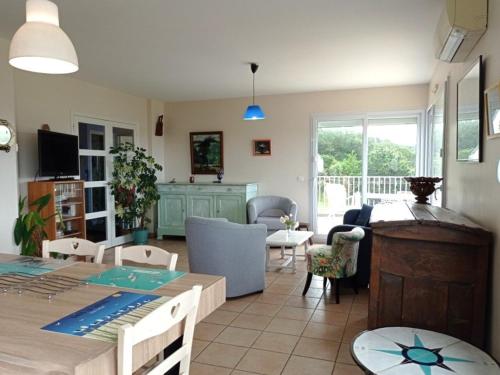une cuisine et un salon avec une table et des chaises dans l'établissement Villa avec terrasse à 400m de la mer à Pleumeur-Bodou - FR-1-368-400, à Pleumeur-Bodou
