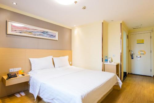 a bedroom with a large white bed in a room at 7Days Inn Changshou Road Subway station in Shanghai