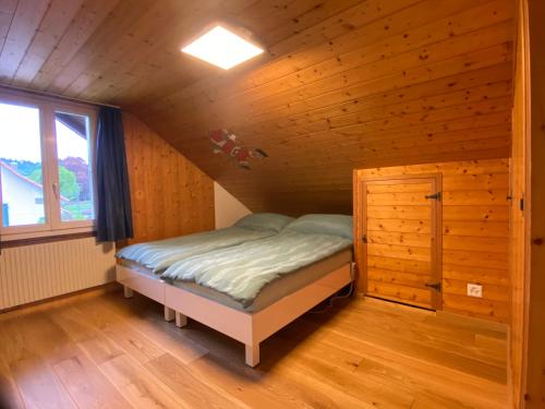 布格多夫Schlafen unterm Dach in Burgdorf CH的一间带窗户的木屋里有一张小床