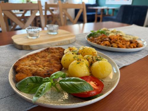 a table with two plates of food on a table at Adalbertus Dom Pielgrzyma in Gniezno
