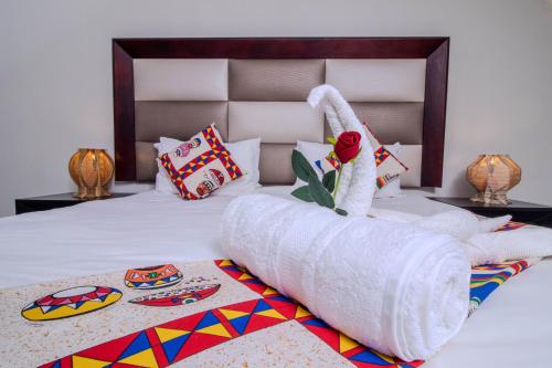 a bedroom with a bed with a large white bedspread at ASANTE MOUNTAIN LODGE in Hazyview