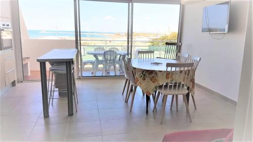 une salle à manger avec une table et des chaises et un balcon dans l'établissement Coeur Plage et commerces Appartement type 3 pour 6 personnes N33, à La Grande Motte